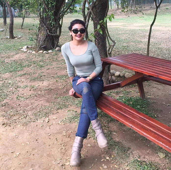 Jaya Ahsan dressed casually and sitting on a park bench